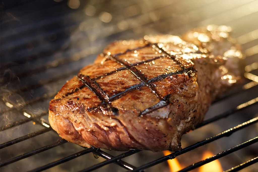 steak searing on a grill